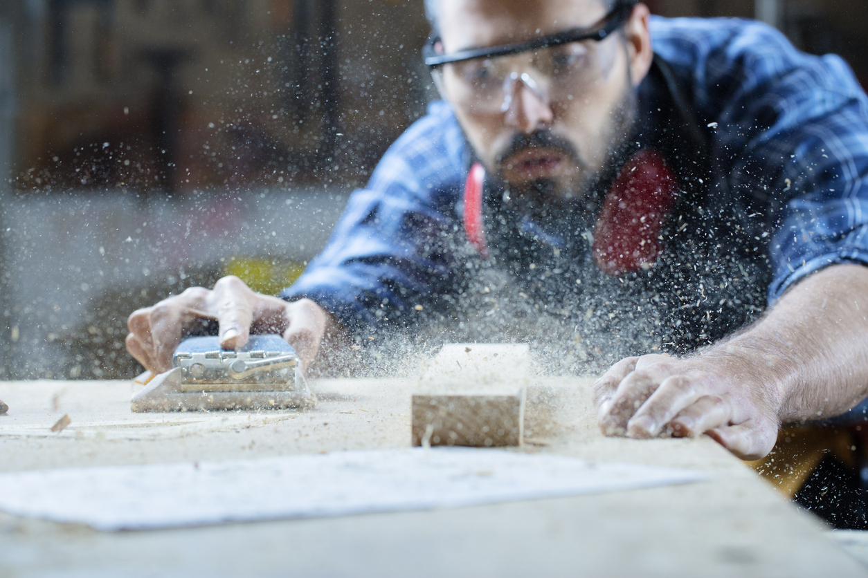 Carpenter blowing off sawdust