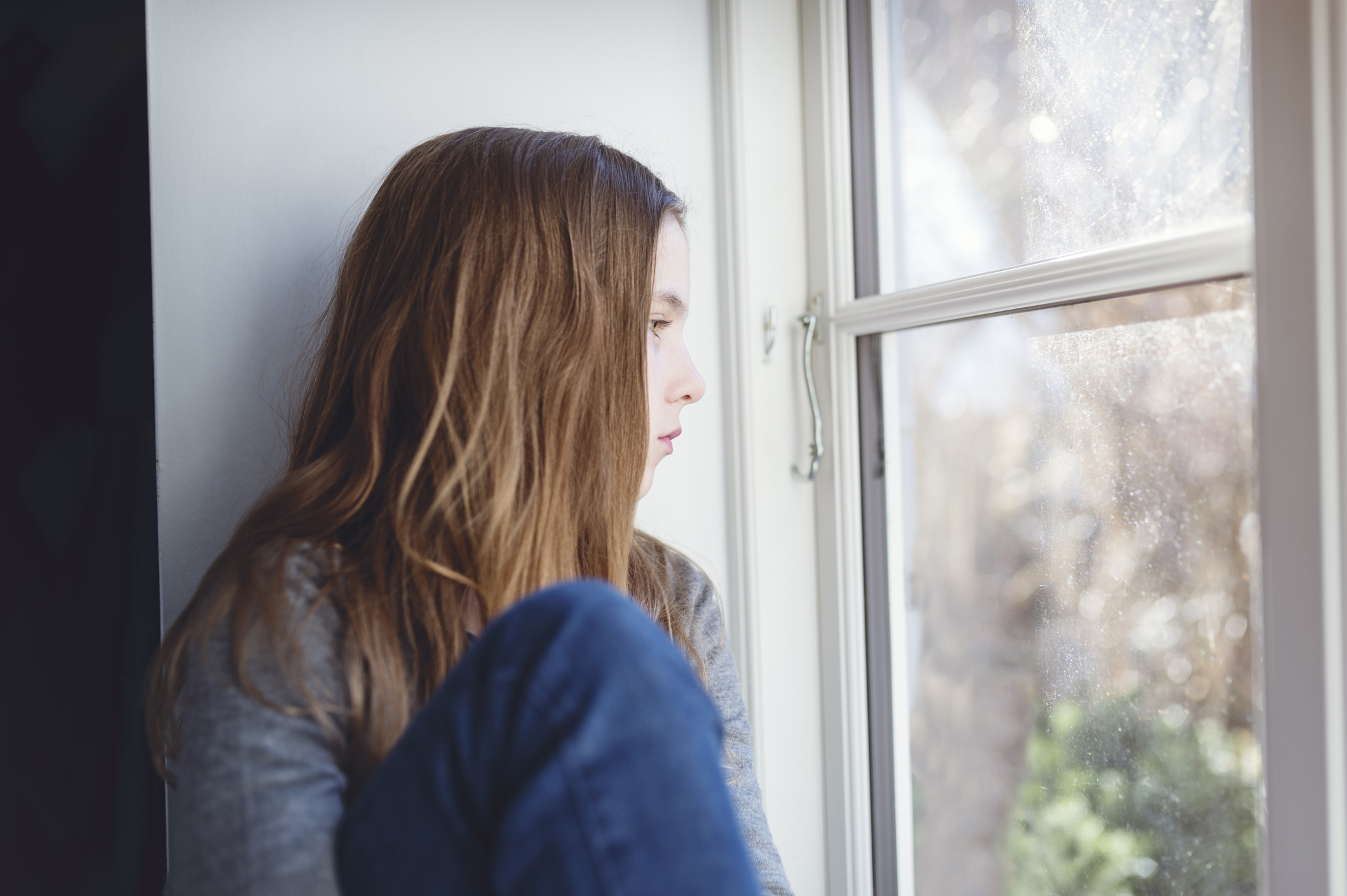 Candid Portrait of a Lonely Twelve Year Old Girl Gazing Out Of a Window