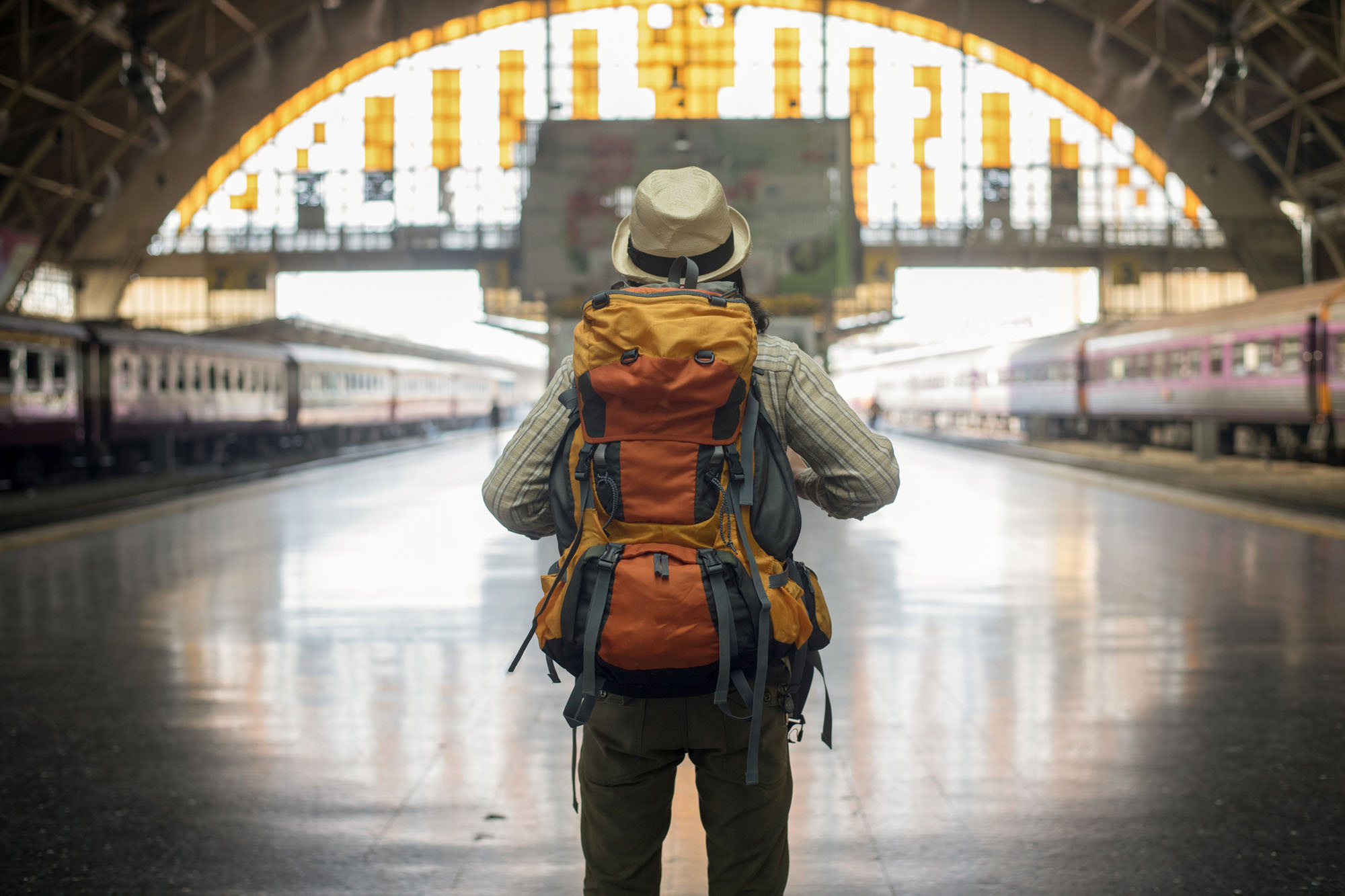 Traveler man waits train on railway platform