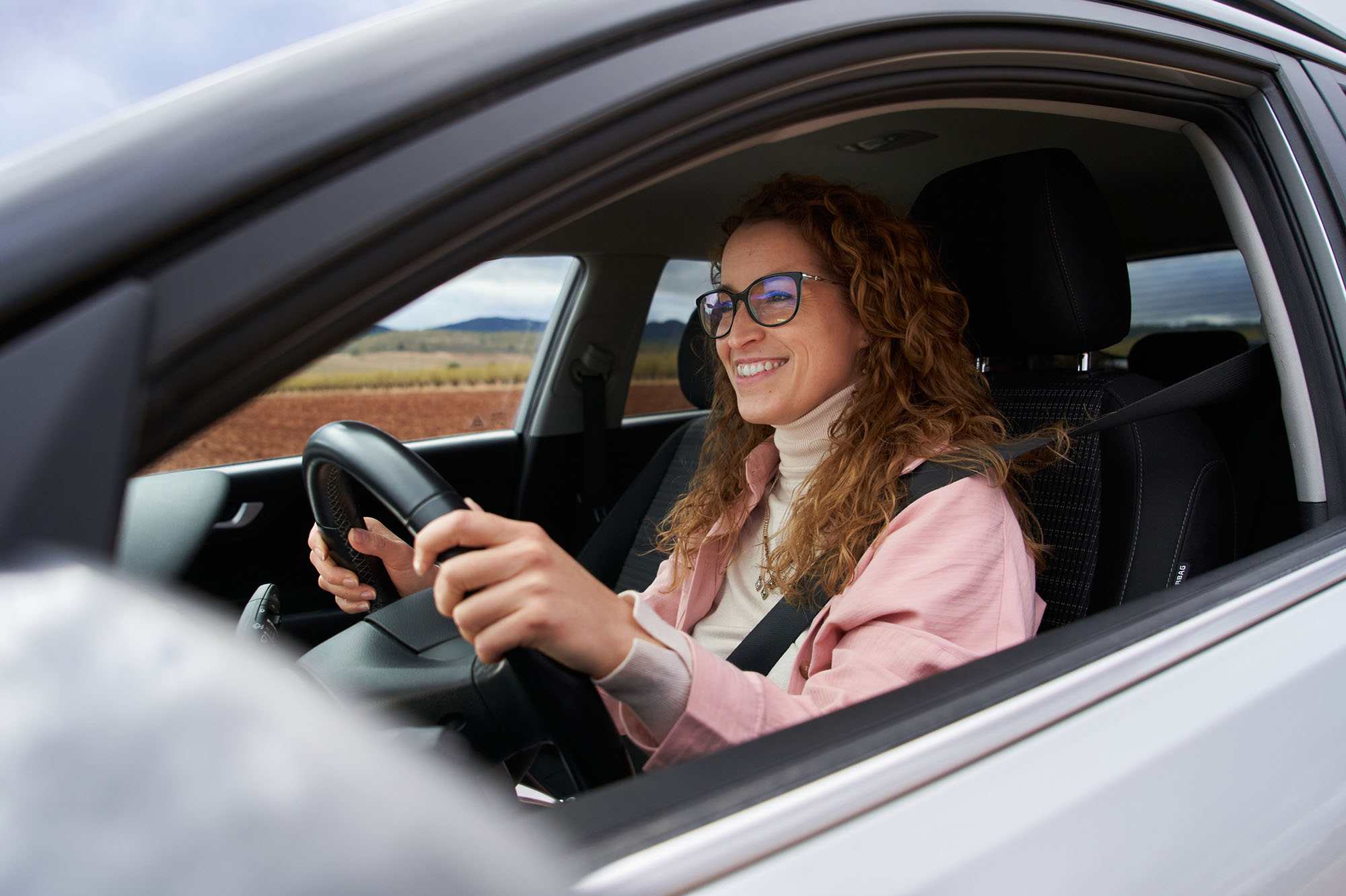 Side view of woman driving cheerfully