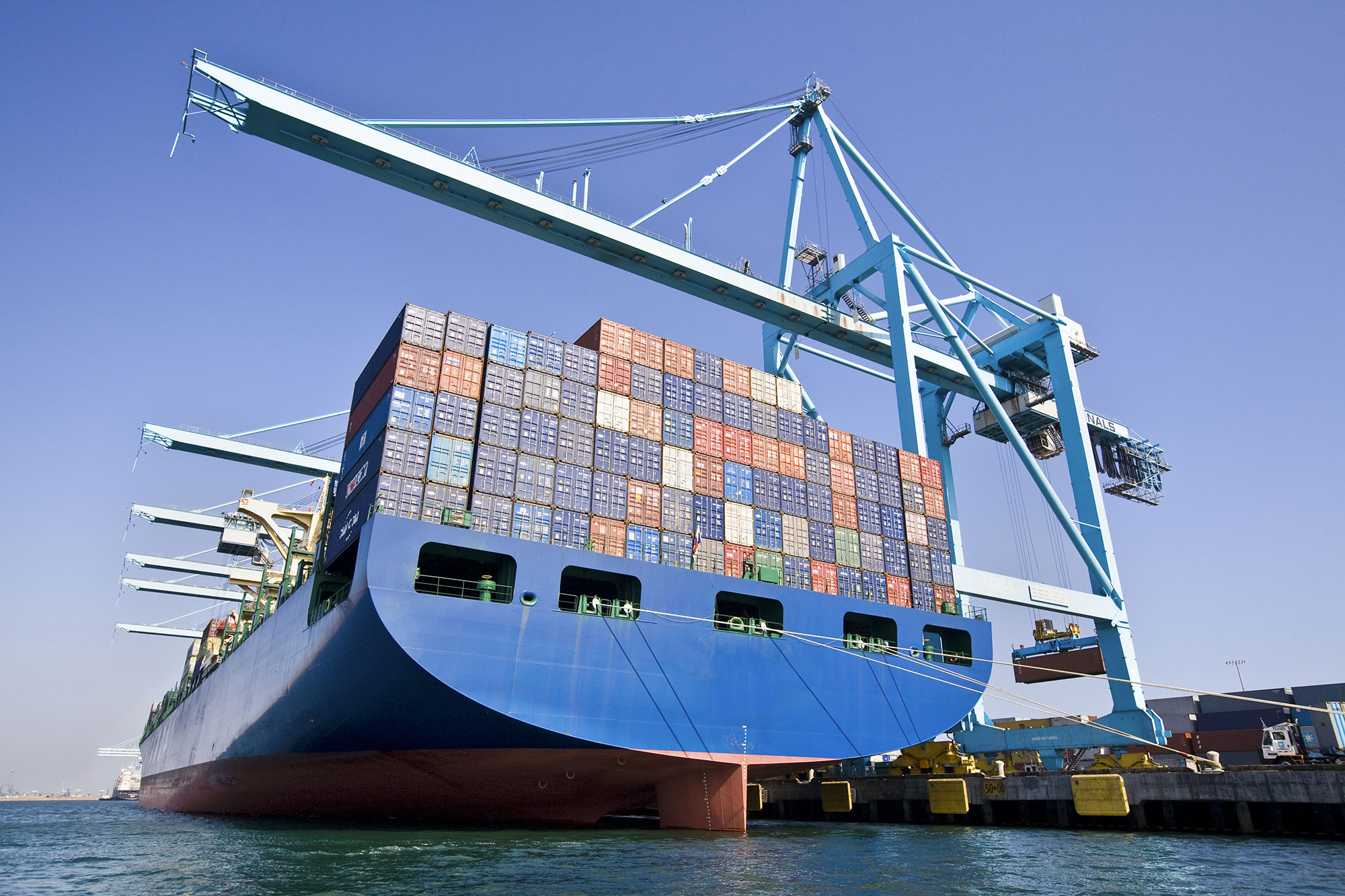 A boat carrying cargo with cranes for lifting up