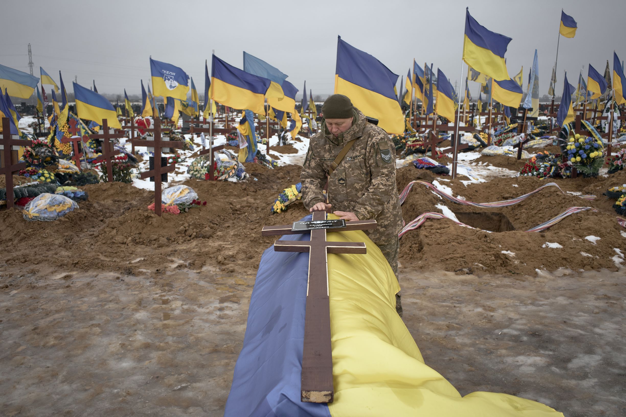Two male hands holding colored in flag of European Unity and Ukraine isolated on grey studio background.