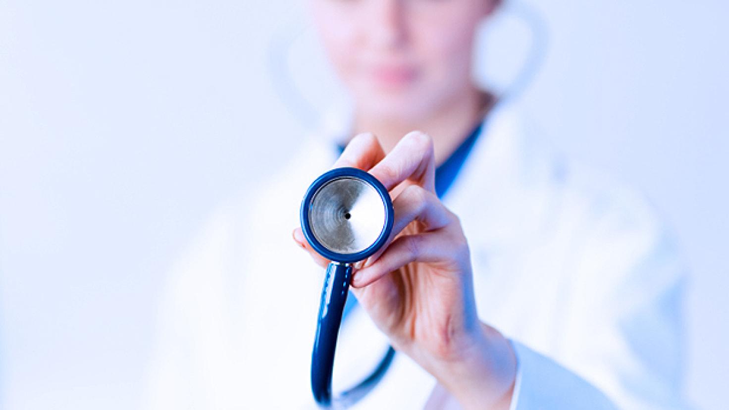Lekarz trzymający stetoskop, skupiający się na obiekcie