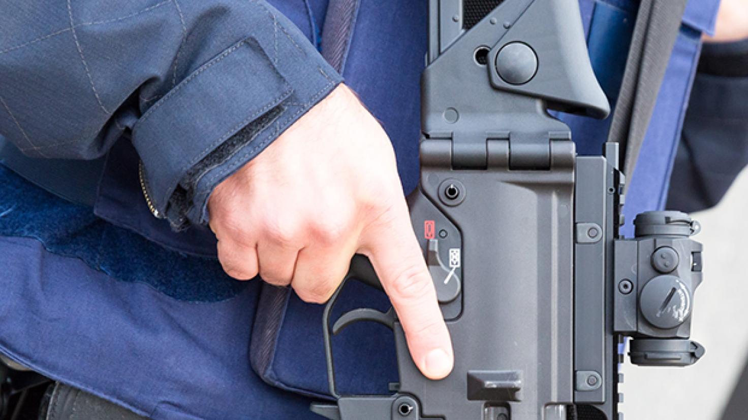 Close up de uma mão segurando uma arma