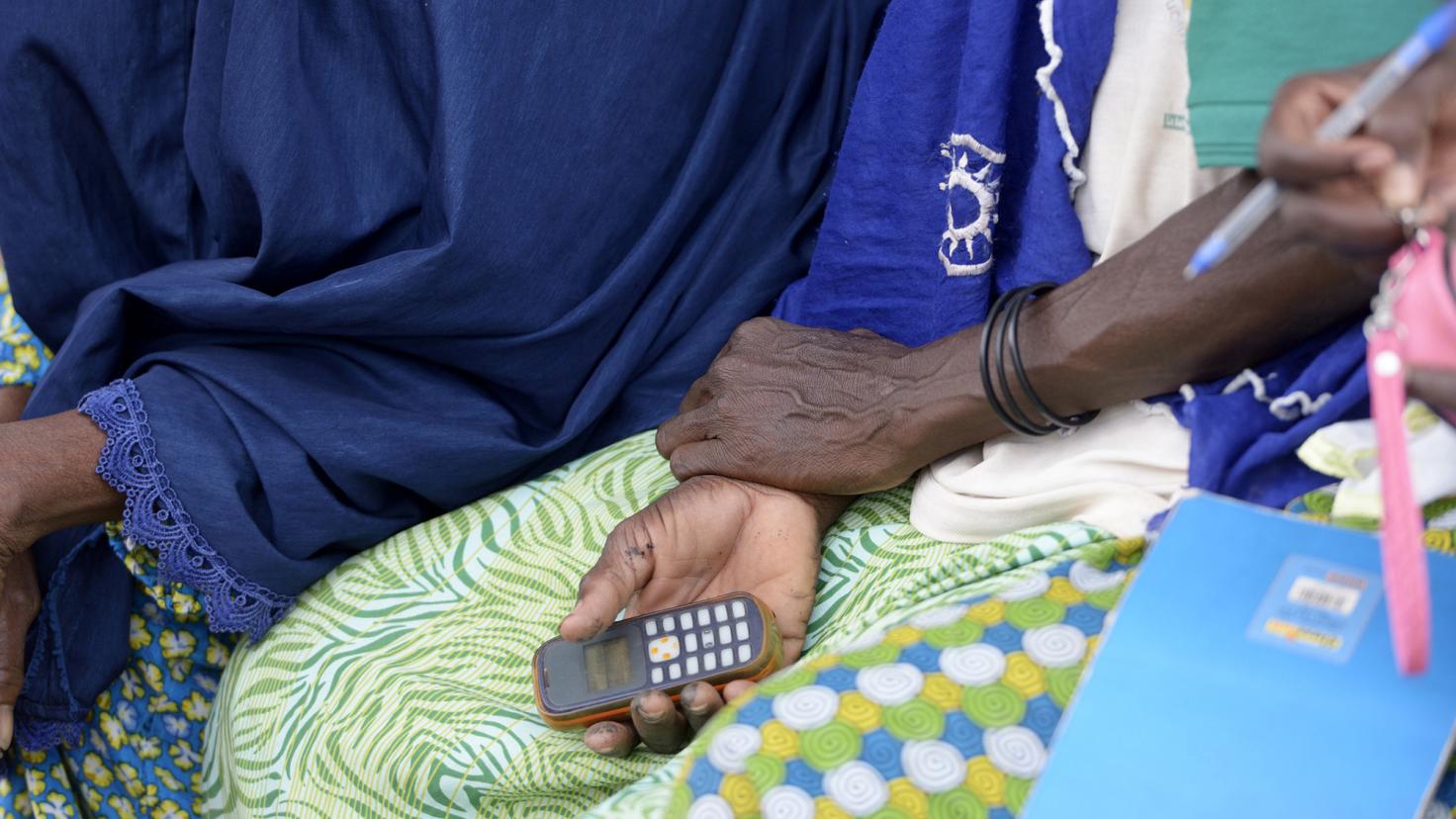 Burkina Faso, žena držící mobilní telefon