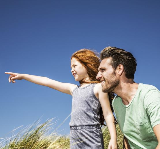 Girl with father pointing into the distance