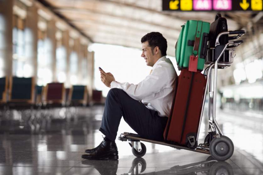 Businessman in airport with mobile phone