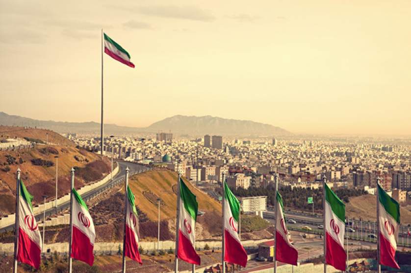 Række af iranske flag foran Teherans skyline