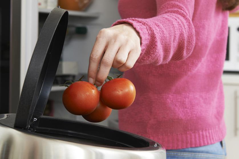 Woman Throwing Away Out Of Date Food In Refrigerator
