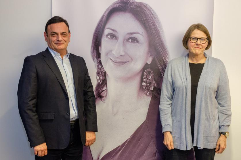David Casa in front of a photo od Daphne  Caruana Galizia