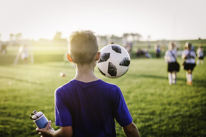 11 year old boy juggling football ball