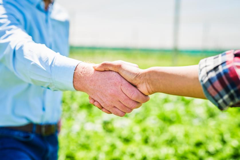 Man and woman shaking hands on a farm