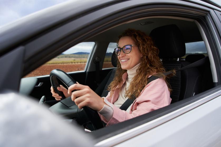 Side view of woman driving cheerfully