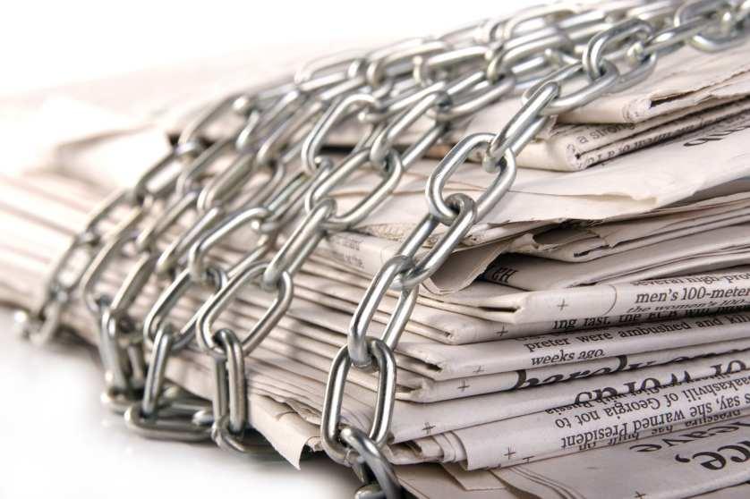 Hromada novin s kovovým řetězem