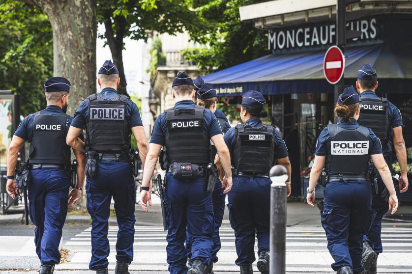 Agenti di polizia in uniforme pattugliano a piedi e garantiscono la sicurezza nelle strade di Parigi, Francia