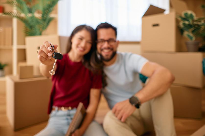 Un couple heureux montre les clés de sa nouvelle maison après avoir emménagé