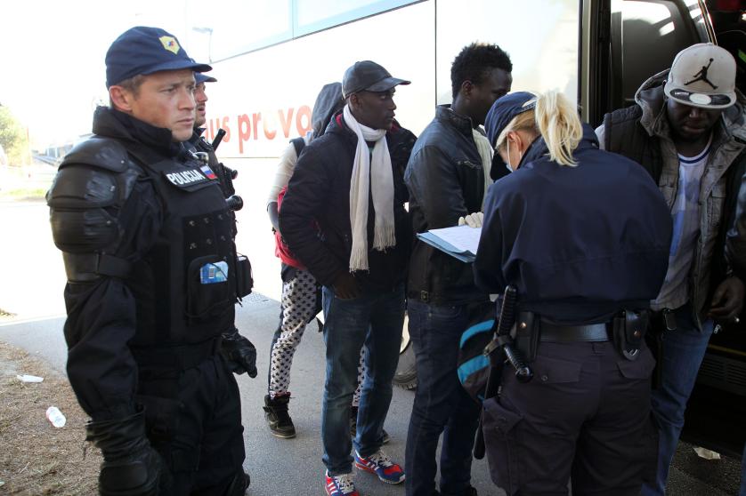 Słoweński policjant na dworcu kolejowym porównuje nazwiska uchodźców i migrantów wsiadających do autobusu do Lublany, a następnie do Sentilj na granicy z Austrią, z listą rejestracyjną.