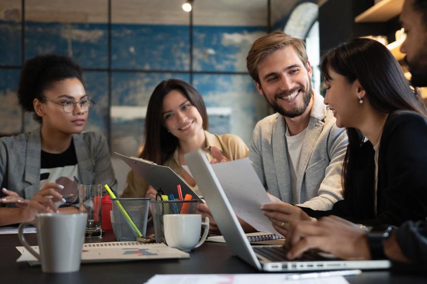 Grupo de jovens multirraciais trabalhando em um escritório moderno. Homens de negócios trabalhando durante uma reunião.