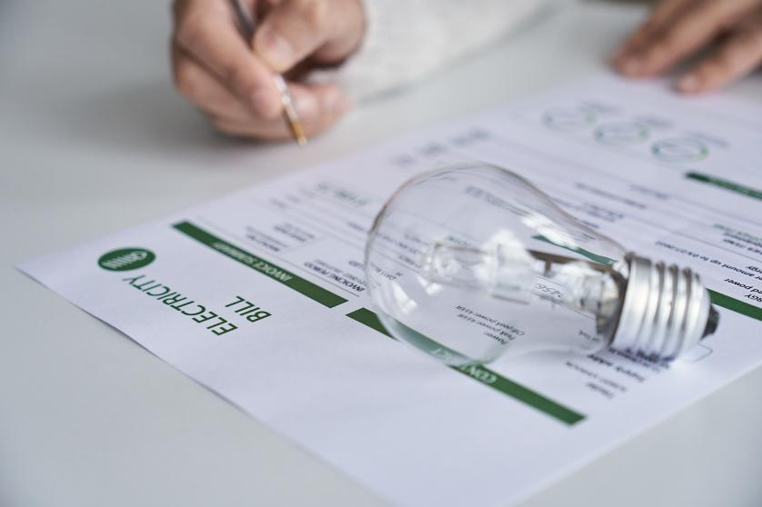 Close up view of a person checking electricity bill at home. Electricity, finance and bills concept.