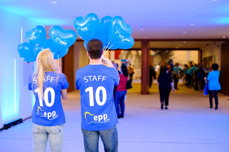 2 člana osoblja koji nose majice 'Staff' drže balone Kluba zastupnika EPP-a na Danima otvorenih vrata parlamenta