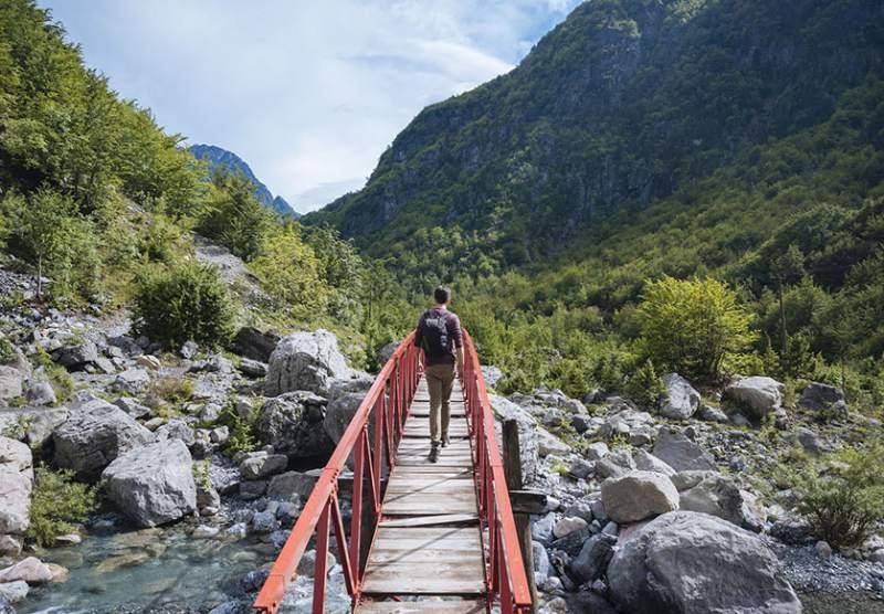 Hiker on a bridge in Grunas Canyon, Theth, Albania