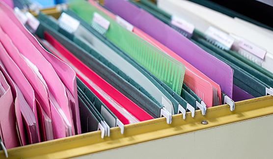 Close up of colourful suspension files in a filing cabinet