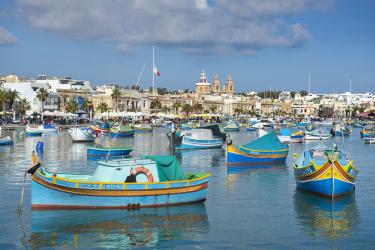 Colourful fishing boats in Marsaxlokk harbour, a small, traditional fishing village in the South Eastern Region of Malta
