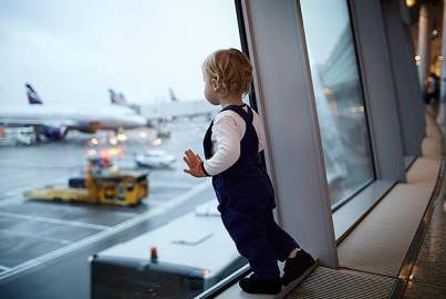 Παιδάκι που κοιτάζει τα αεροπλάνα στο αεροδρόμιο