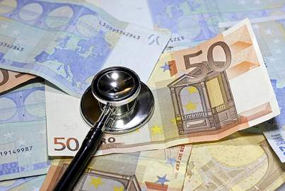 Stethoscope doctor leaned on many euro currency banknotes