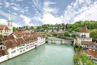 Church, bridge and houses with tiled rooftops in Bern, Switzerland