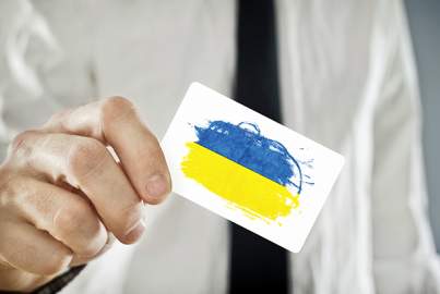 Ukrainian Businessman holding business card with Ukraine Flag