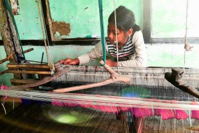 Φωτογραφία μικρού κοριτσιού να δουλεύει σε υφαντήριο