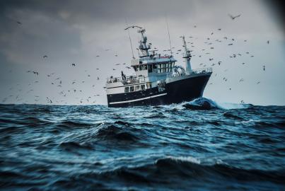 Fishboat vessel fishing in a rough sea