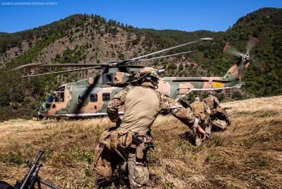 a soldier running towards a military helicopter
