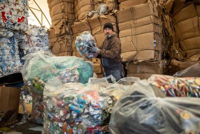Un trabajador se encarga de empaquetar y separar latas y botellas para reciclarlas.