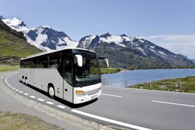 Ônibus branco cruzando os Alpes