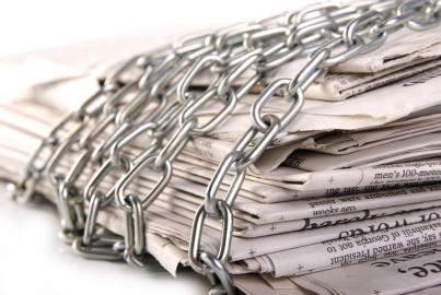 Pile of newspapers with metal chain