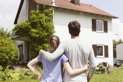Couple in garden looking at residential house
