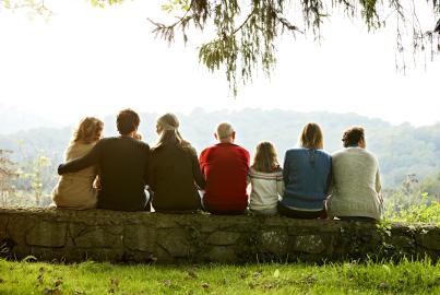 Multi-generation family relaxing on retaining wall