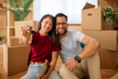 Un couple heureux montre les clés de sa nouvelle maison après avoir emménagé