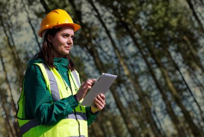Portrait of female engineer with hardhat using digital tablet