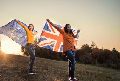 Deux femmes debout sur la colline tenant le drapeau de l'UE et le drapeau du Royaume-Uni