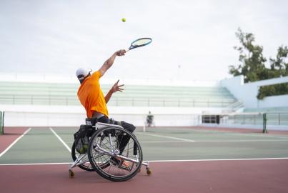 Disabled tennis player hits the ball