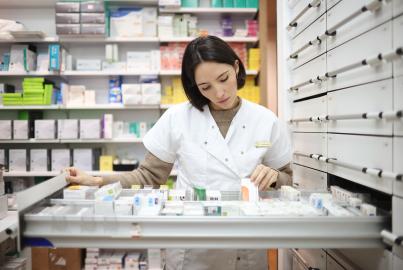 A pharmacist taking inventory of drugs in the pharmacy's backroom