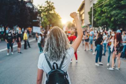 Young woman with a raised fist protesting in the street