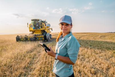 Female Farmer is Holding a Digital Tablet in a Farm Field. Smart Farming