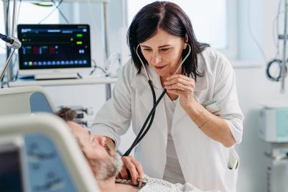 Doctor listening to patient's heart and breathing with stethoscope